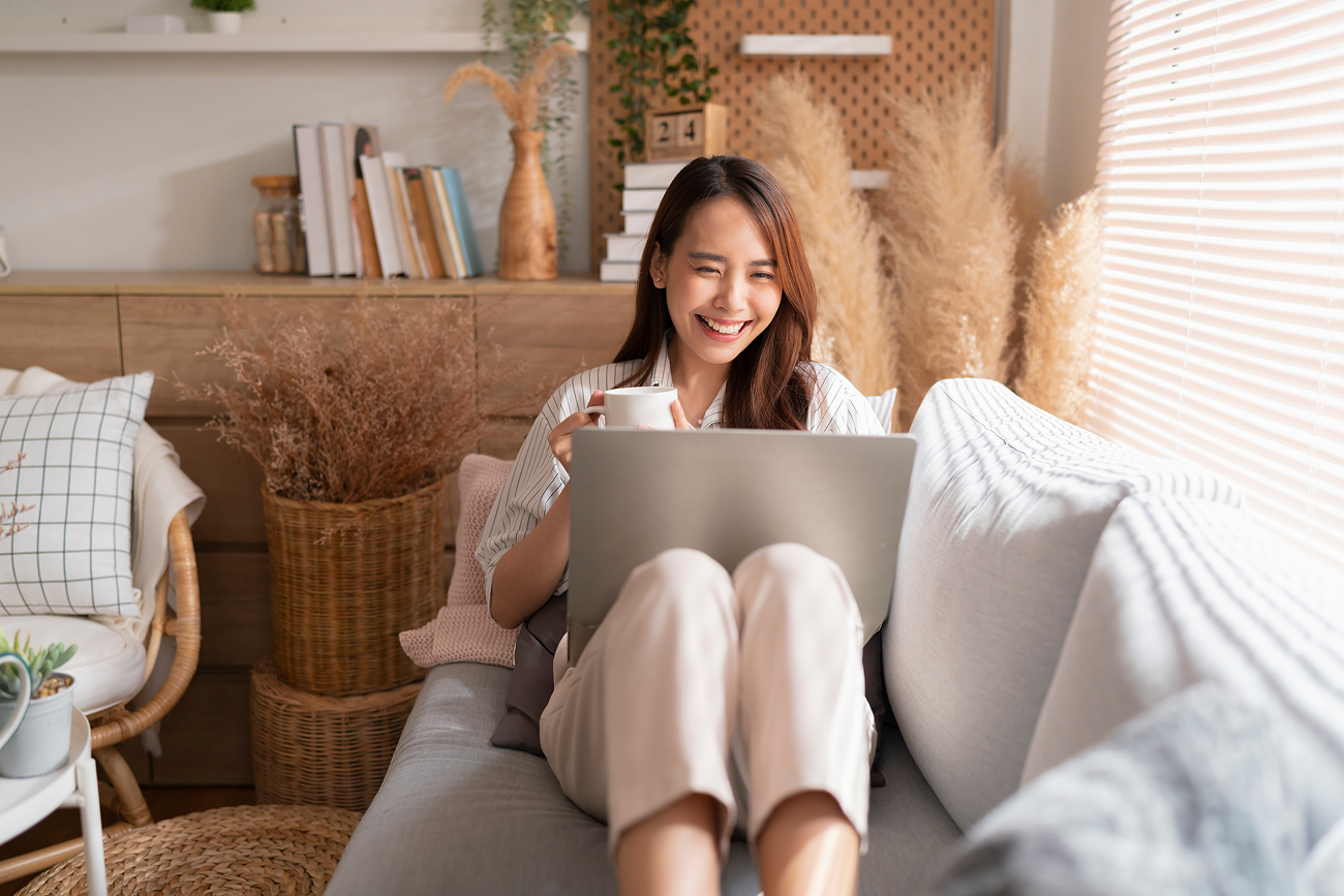 woman sitting on a sofa using her laptop for a better stress-free lifestyle